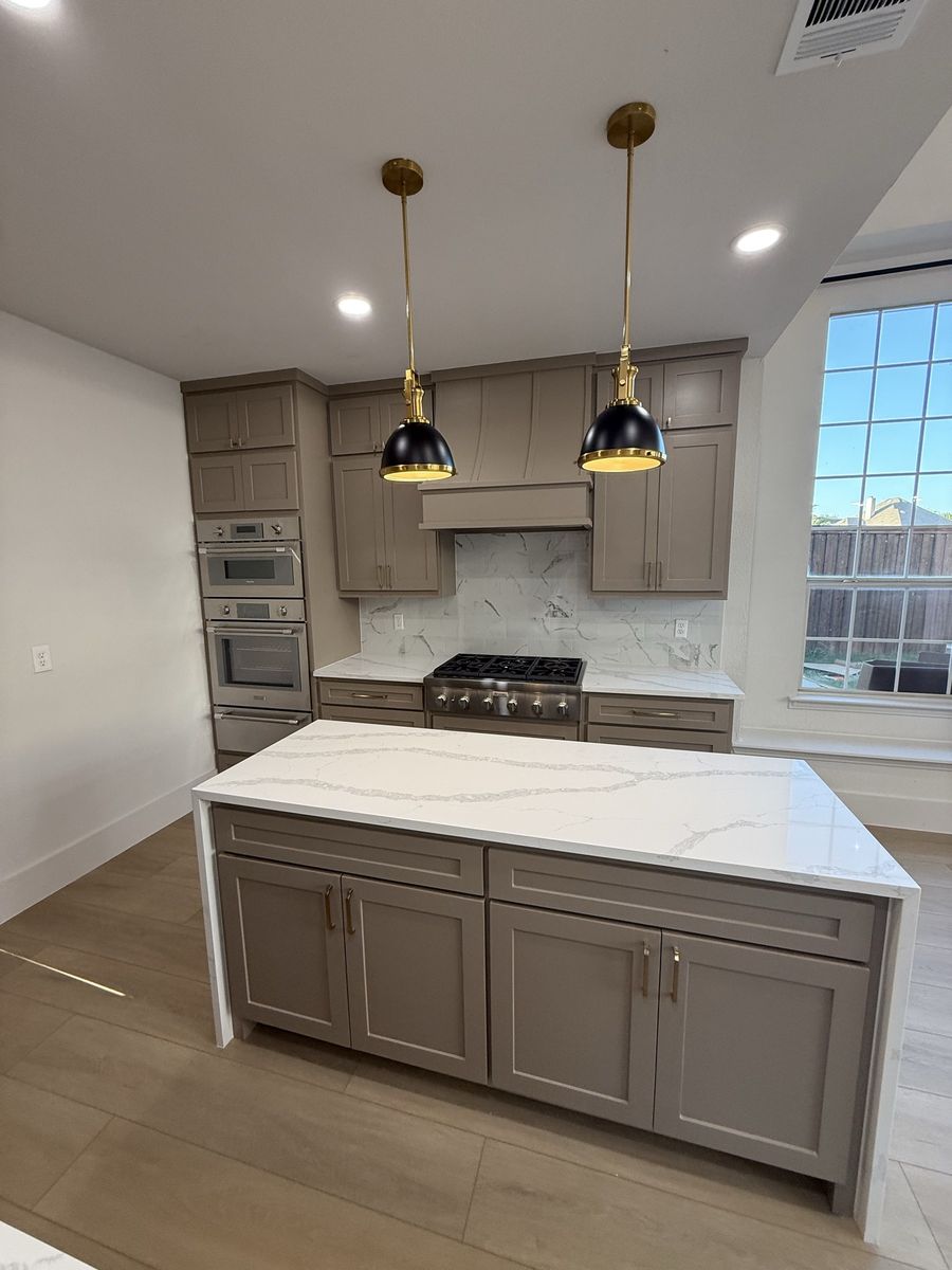 Custom kitchen with brass pendants and waterfall island