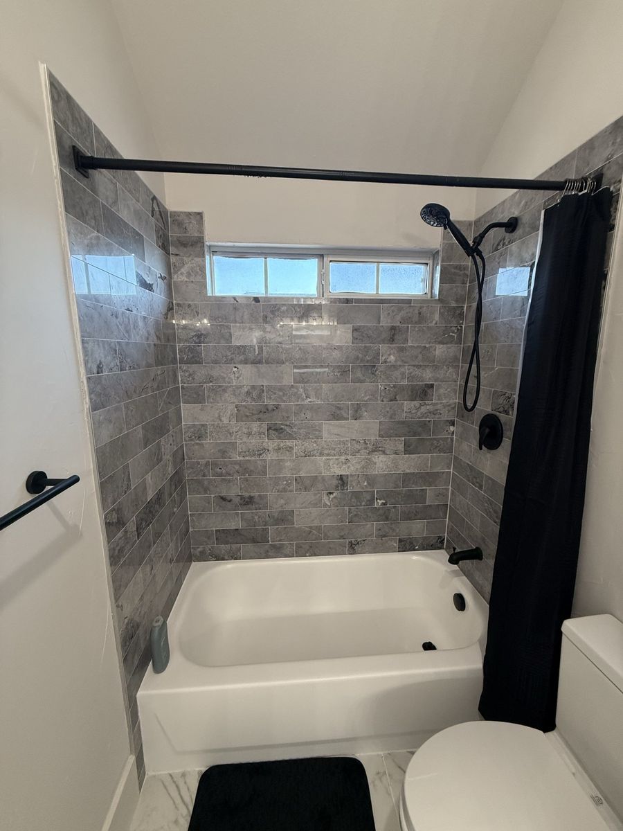 Tub and shower with grey stacked tile