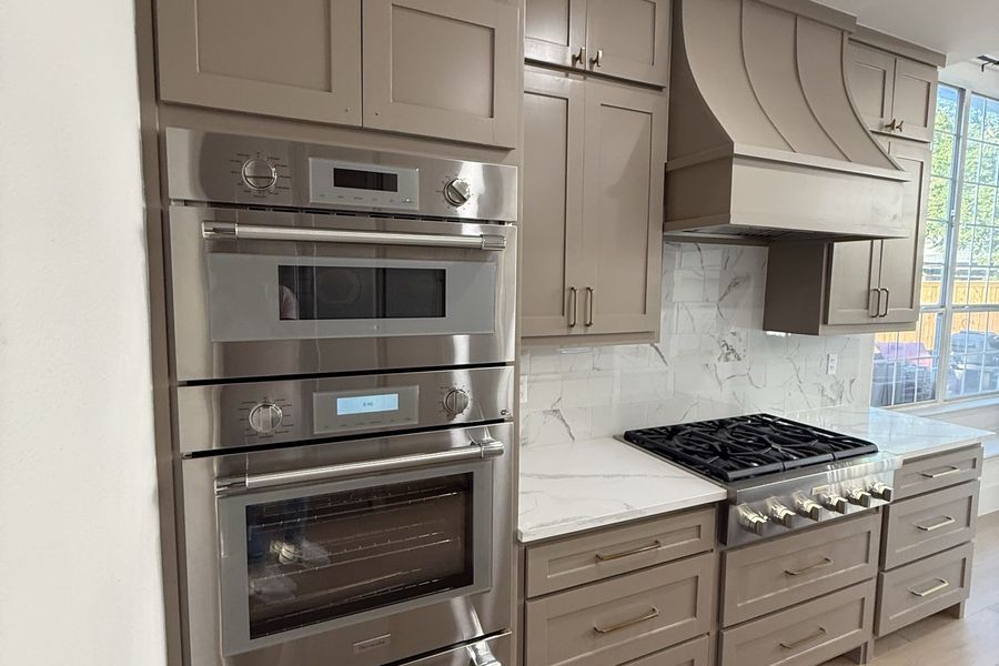 Gas range with marble slab backsplash and double ovens